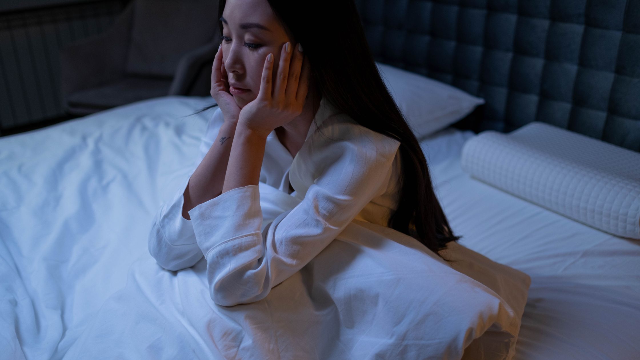 a lady sitting up in bed alone - financial implication
