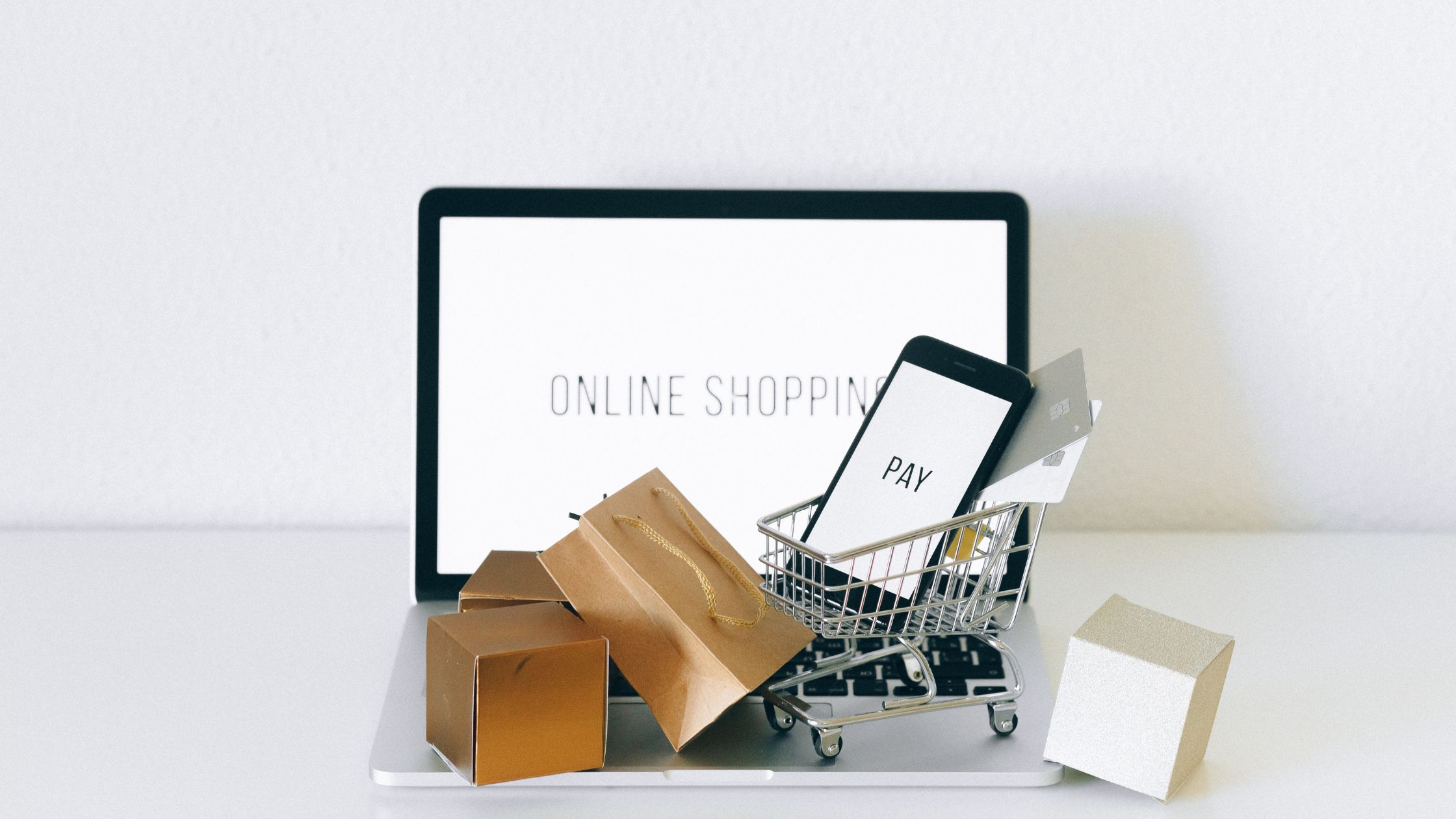 picture of shopping bags, trolley, laptop and a phone