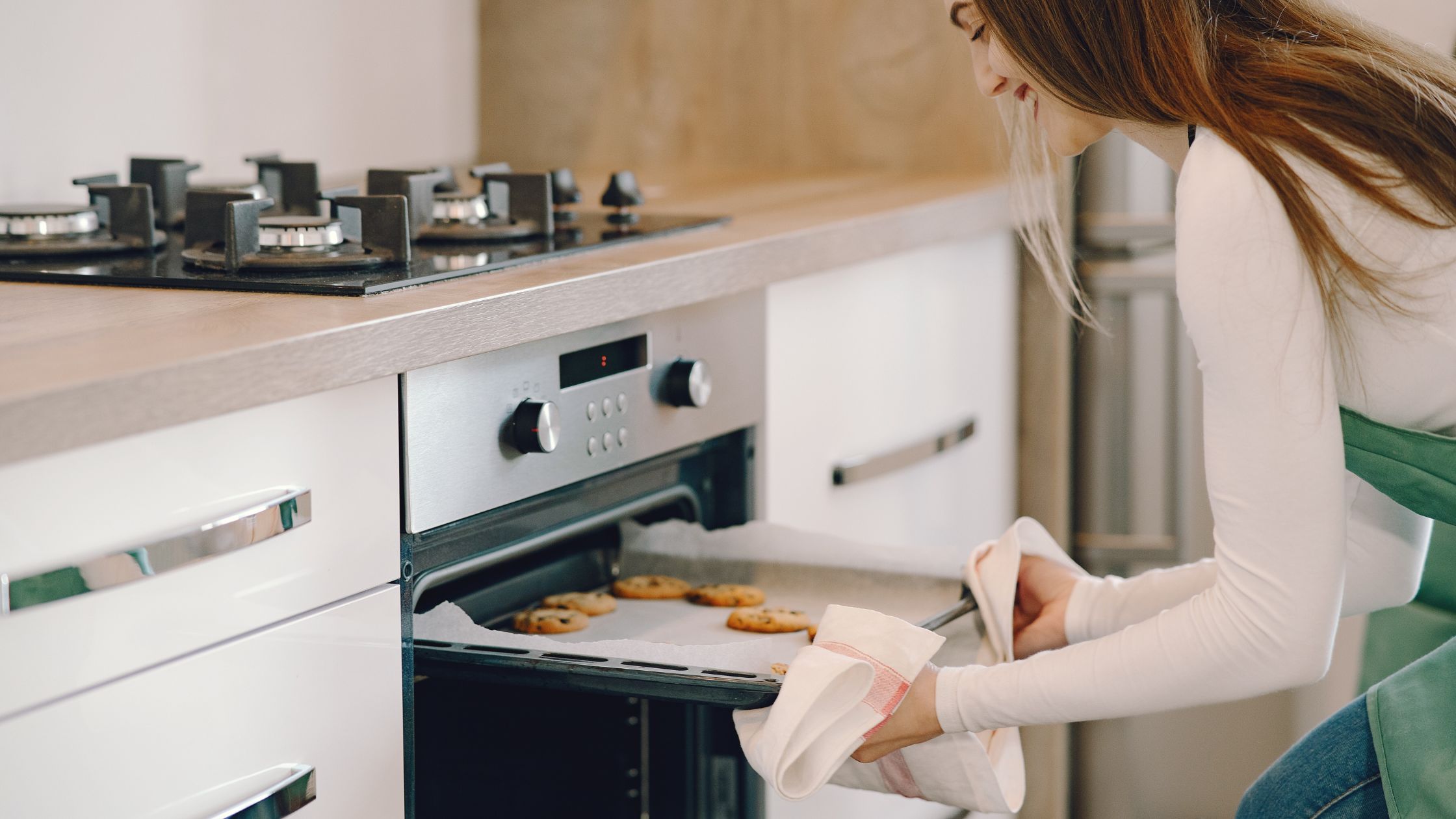 picture of a lady putting baked items in an oven