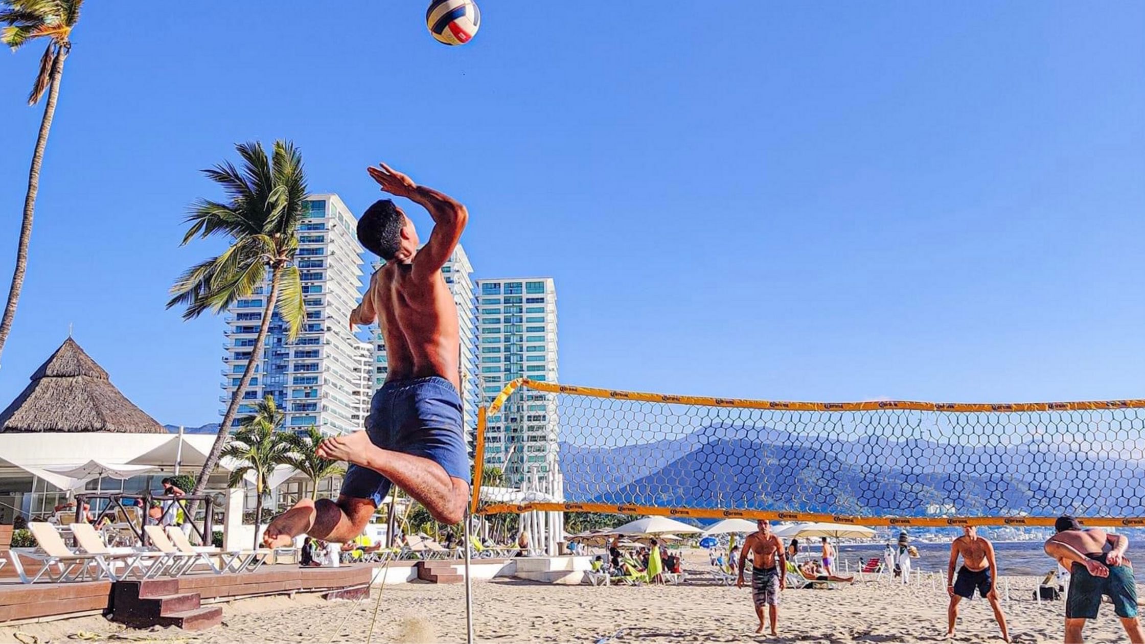 a guy playing hand ball at the beach