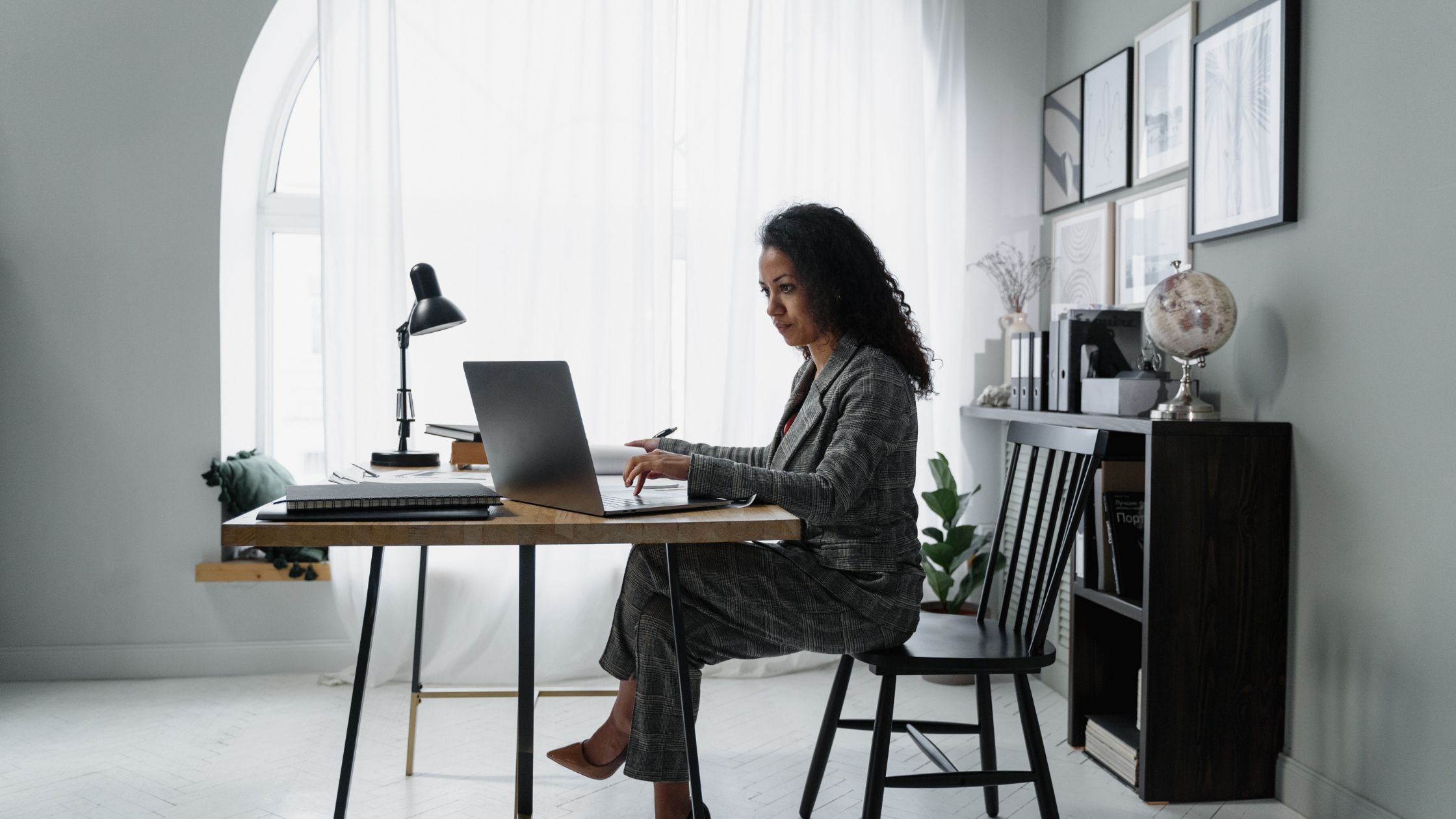 A woman busy typing on a laptop in a home office - get rich from nothing to become a millionaire 