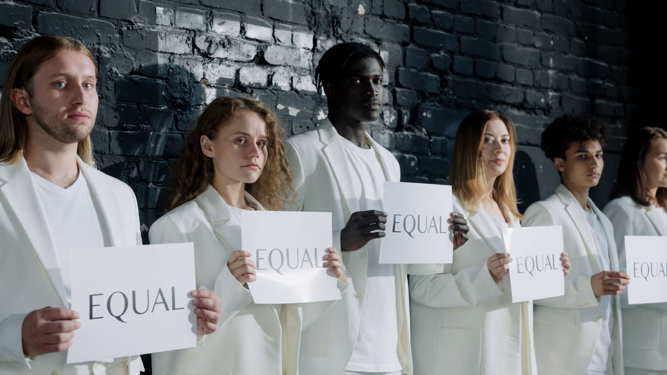 men and woman holding pieces of paper with the word "equal"