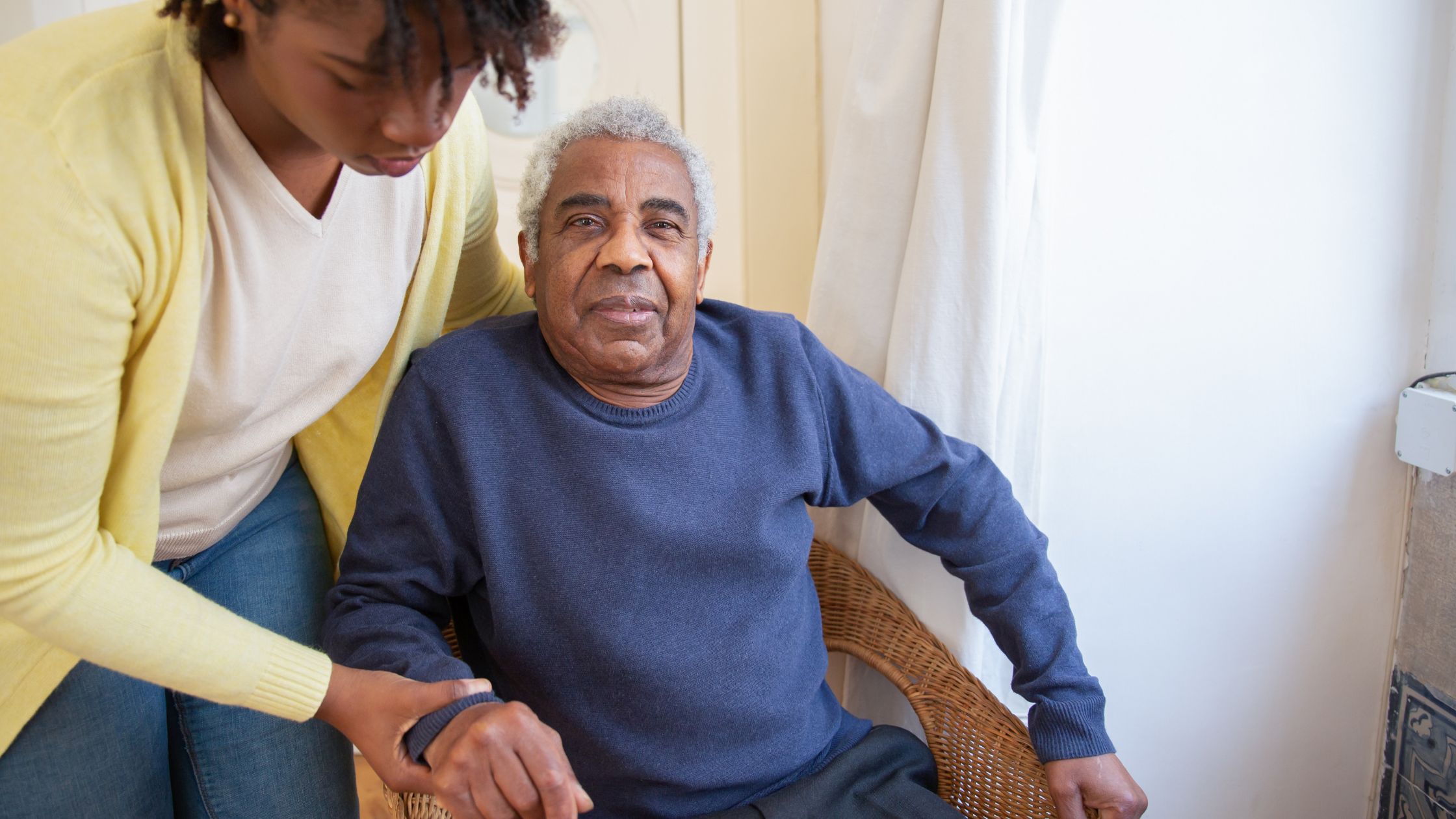 A picture of a woman helping an old man in a nursing home.