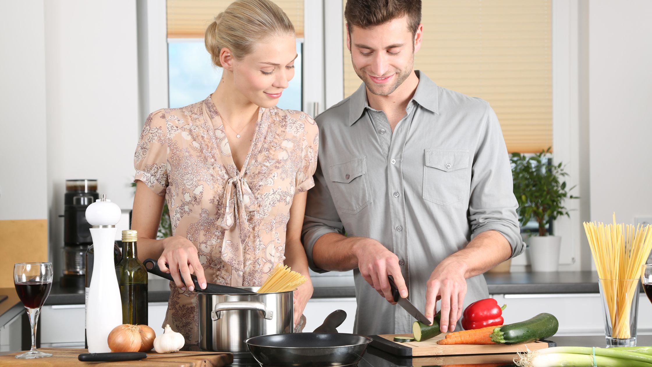 a couple cooking at home - Realistic Ways to Save Money Cooking At Home