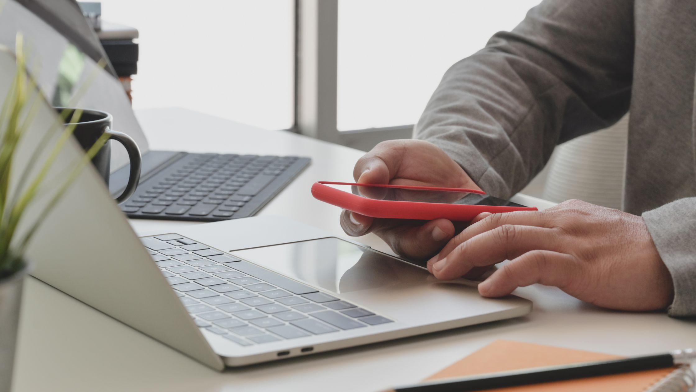 a person doing digital marketing using a phone and a laptop