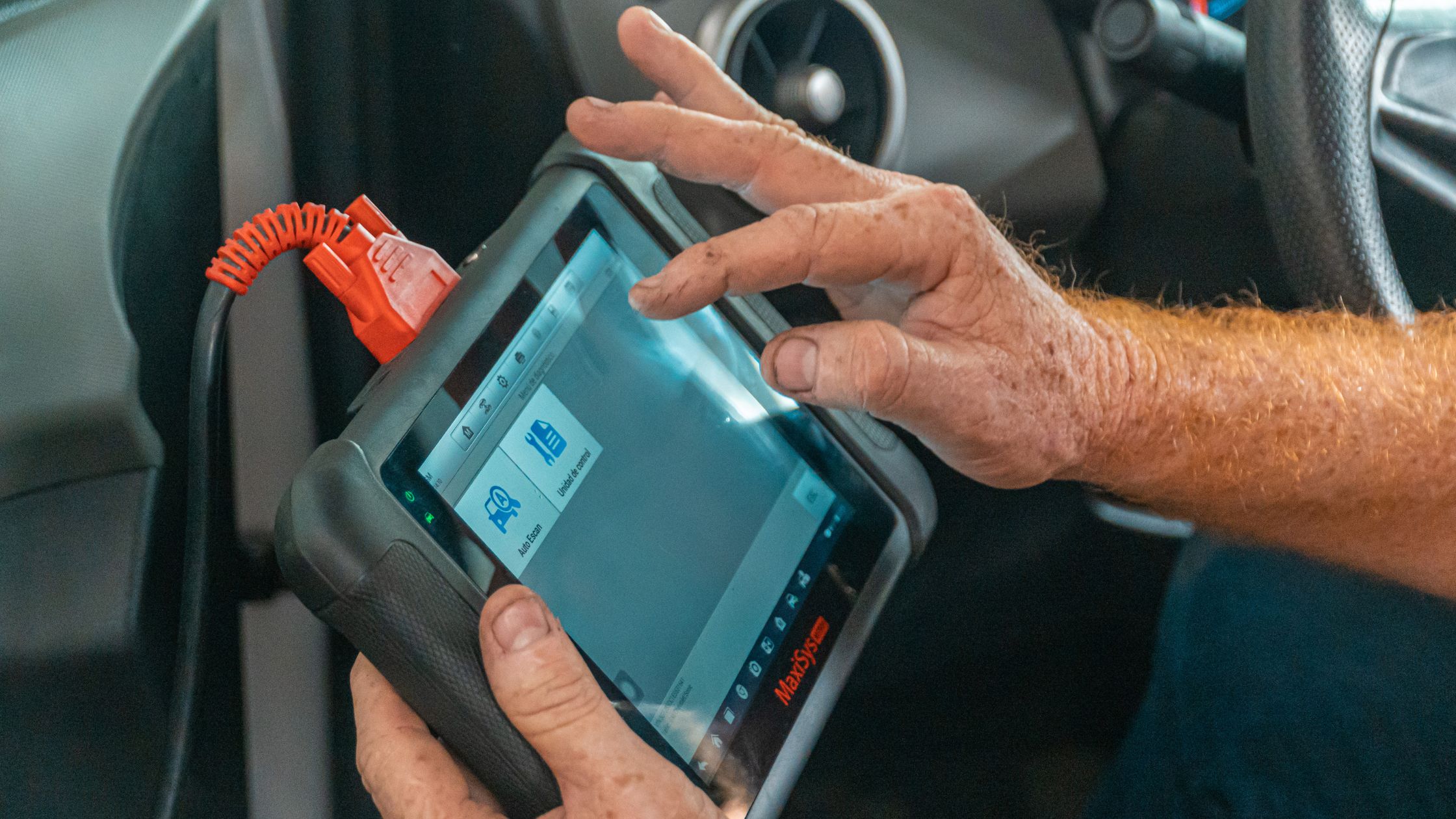 A picture of a car mechanic installing a device