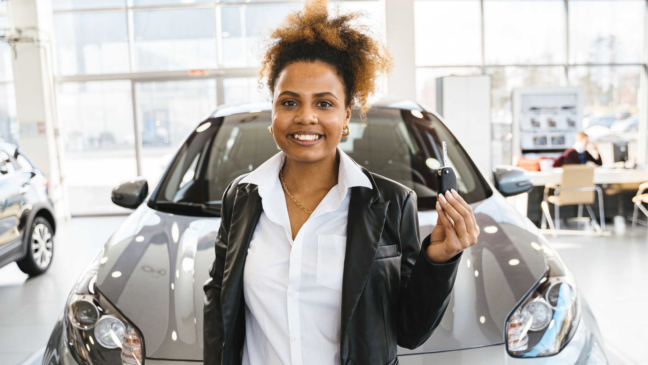 Lady holding a key for her new car